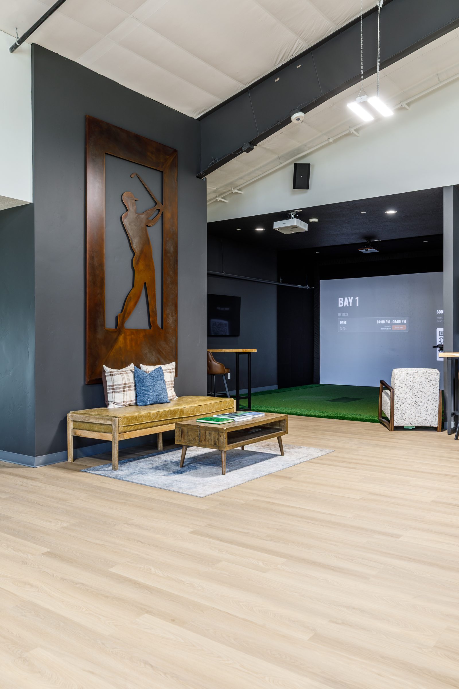 Entry lounge with a steel golfer sculpture, looking into Bay 1