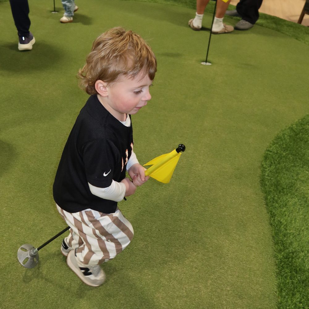 A young guest putting at the lounge's opening