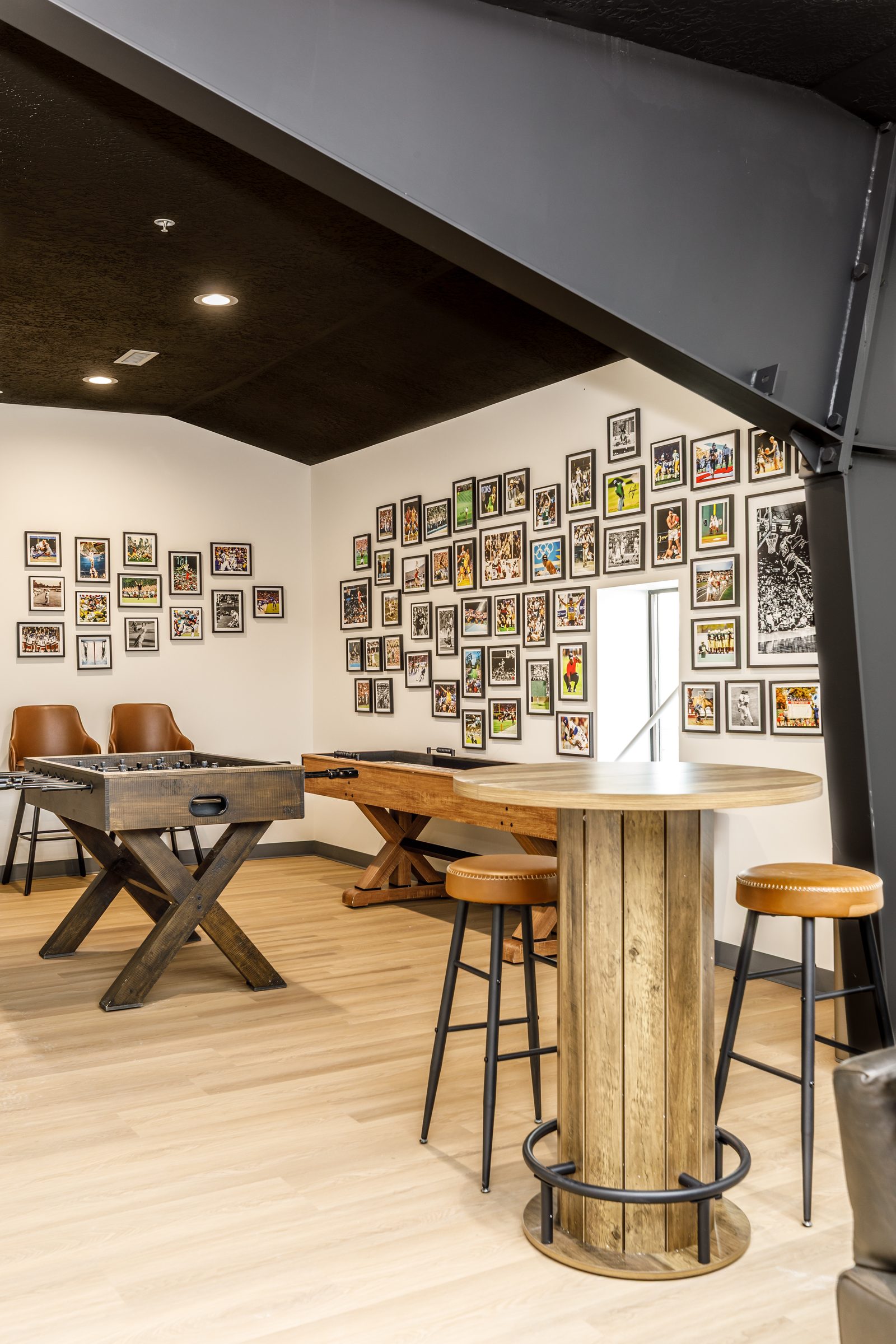 Game room with foosball, shuffleboard, and a wall of sports photos