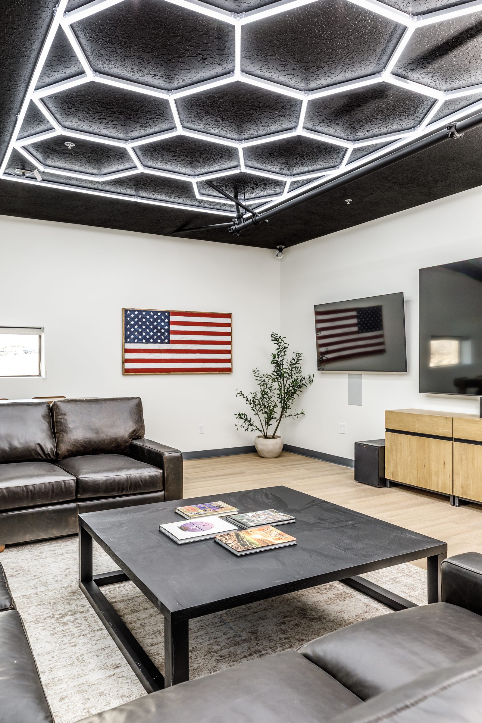 Man cave with leather couches and TVs